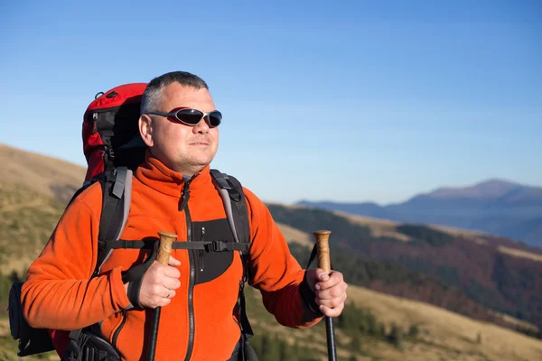 Hombre de excursión en las montañas con una mochila y tienda de campaña . — Foto de Stock