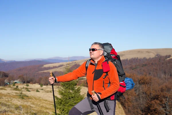 Muž, turistika v horách s batohem a stan. — Stock fotografie