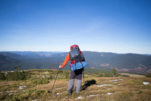 Man hiking in the mountains with a backpack and tent. — Stock Photo, Image