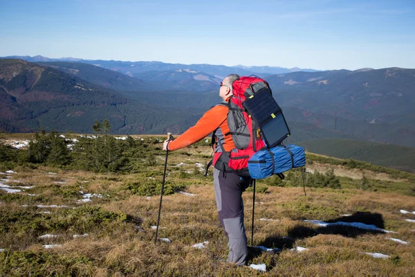 Man hiking in the mountains with a backpack and tent. — Stock Photo, Image