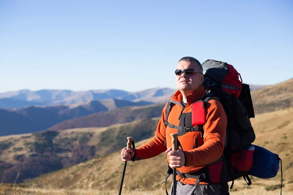 Man hiking in the mountains with a backpack and tent. — Stock Photo, Image