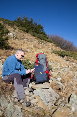 Çadır için bağlı güneş paneli. Güneş'ten cep telefon ücretleri yanında oturan adam.