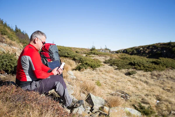 The solar panel attached to the tent. The man sitting next to mobile phone charges from the sun. — Stock Photo, Image