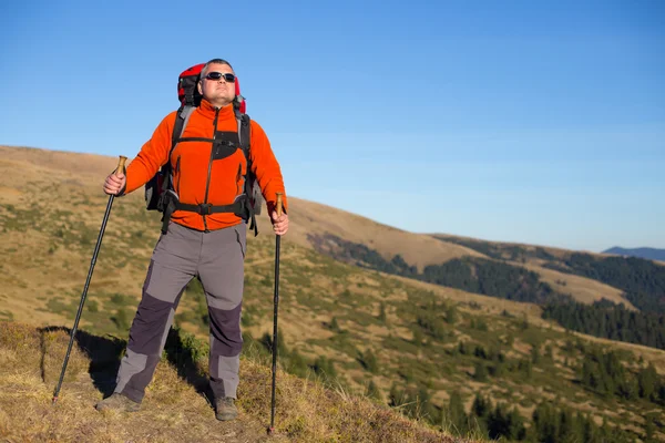 Hombre de excursión en las montañas con una mochila y tienda de campaña . — Foto de Stock