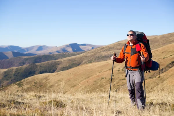 Adam bir sırt çantası ve çadır ile dağlarda hiking. — Stok fotoğraf