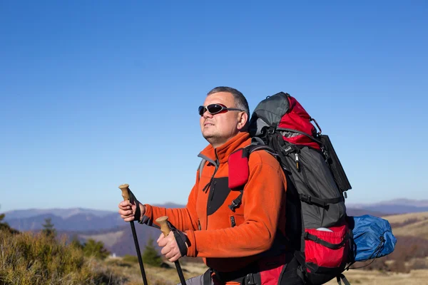 Adam bir sırt çantası ve çadır ile dağlarda hiking. — Stok fotoğraf