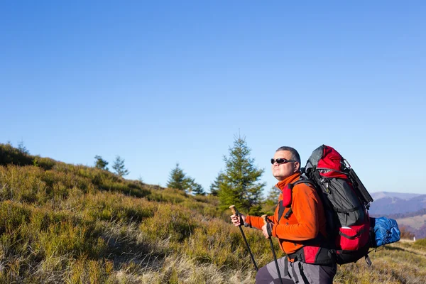 Man vandring i bergen med en ryggsäck och tält. — Stockfoto