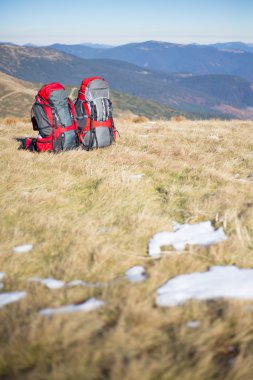 Kırmızı sırt çantası ayakta dağın zirvesinde.