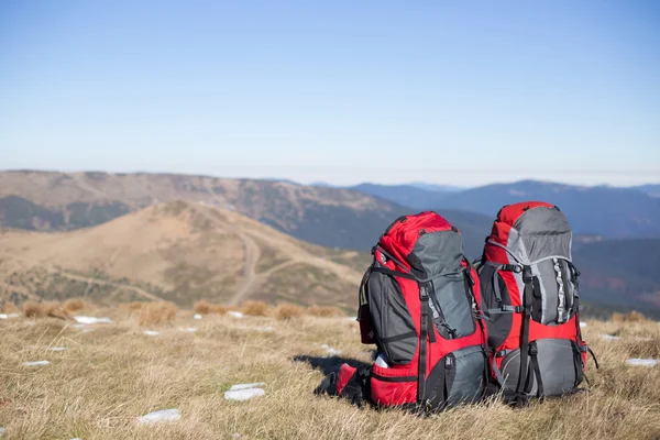 Röd ryggsäck stående på toppen av berget. — Stockfoto