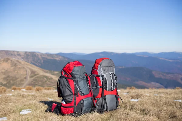 Roter Rucksack auf dem Gipfel des Berges. — Stockfoto