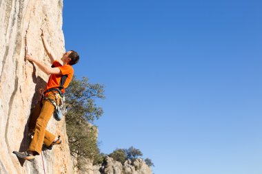 Uçurumun kenarında asılı genç bir tırmanıcı.