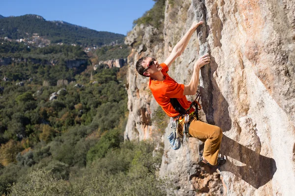 Young male climber hanging by a cliff. — Stock Photo, Image