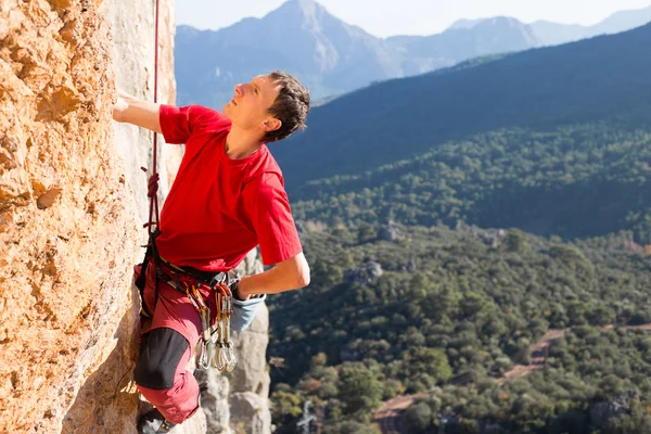 崖にぶら下がっている若い男性登山家. — ストック写真