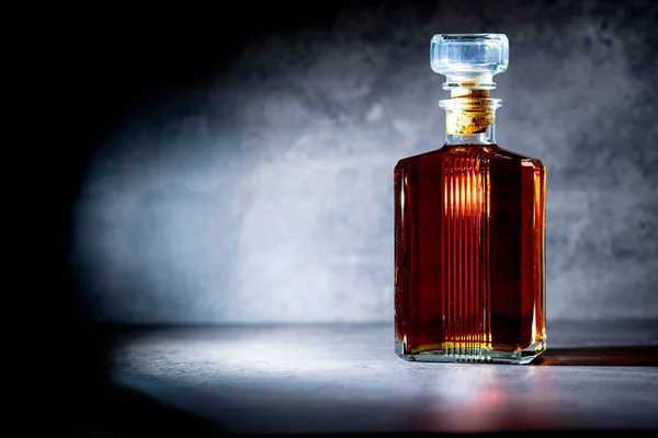 Quadratische Whiskeyflasche Lichtstrahlen Auf Dunkelgrauem Zementhintergrund — Stockfoto