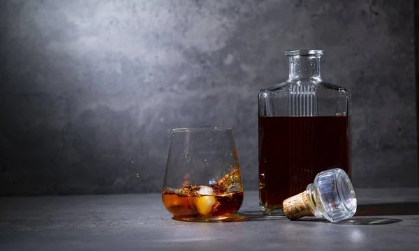 Quadratische Whiskeyflasche Und Glas Mit Eis Auf Dunkelgrauem Zementhintergrund — Stockfoto