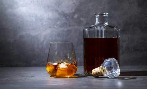 Quadratische Whiskeyflasche Und Glas Mit Eis Auf Dunkelgrauem Zementhintergrund — Stockfoto