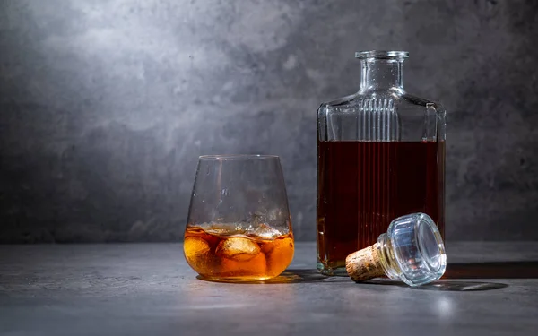 Quadratische Whiskeyflasche Und Glas Mit Eis Auf Dunkelgrauem Zementhintergrund — Stockfoto