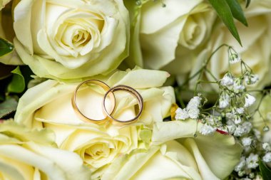 Alyanslar, iki bardak ve bir buket beyaz gül.