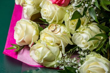 Beyaz bir gül goncasında iki alyans.