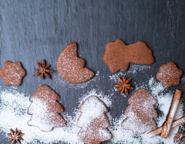 Noel kurabiyesi ve tarçınlı ardesia üzerine krema serpiştirilmiş şeker.