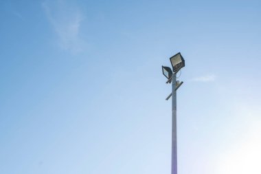 Mavi gökyüzüne karşı iki projektörlü sütun