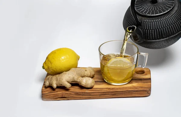 生姜和一杯柠檬茶放在白底的橄榄板上 — 图库照片