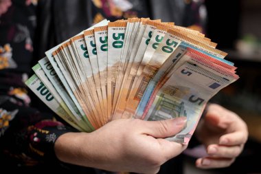 Siyah arka planda bir adamın ellerinde Avrupa tarzı banknotlar