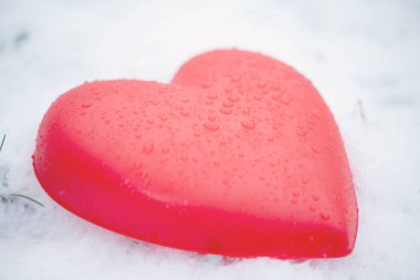Karda su damlaları olan kırmızı kalp.
