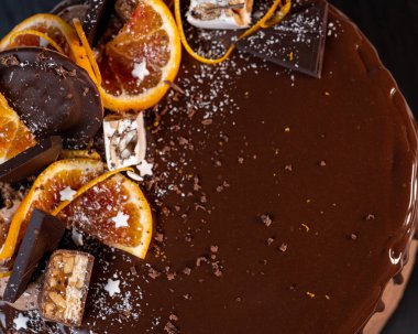 Portakallı güzel çikolatalı pasta. Koyu gri arka planda damla damla çikolata.