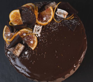 Portakallı güzel çikolatalı pasta. Koyu gri arka planda damla damla çikolata.