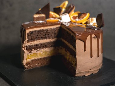 Portakallı güzel çikolatalı pasta. Koyu gri arka planda damla damla çikolata.