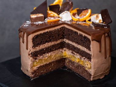 Portakallı güzel çikolatalı pasta. Koyu gri arka planda damla damla çikolata.