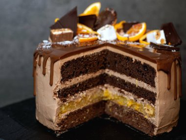 Portakallı güzel çikolatalı pasta. Koyu gri arka planda damla damla çikolata.