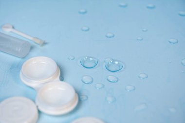 Su damlaları ile mavi arkaplanda kontak lensler
