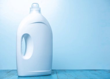 Mavi arka planda temizleyici etiketi olmayan beyaz şişeler.