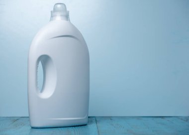 Mavi arka planda temizleyici etiketi olmayan beyaz şişeler.