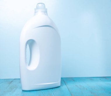 Mavi arka planda temizleyici etiketi olmayan beyaz şişeler.