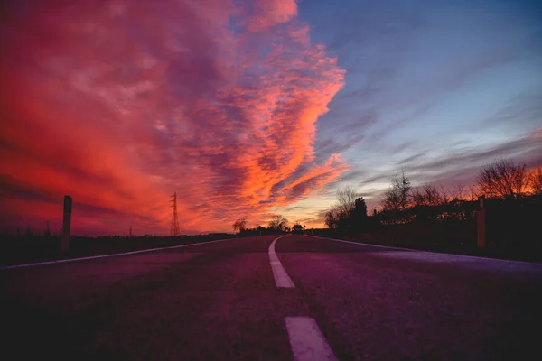 Güzel kırmızı-pembe gün batımı ve tarlalarda yol