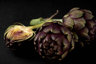 Koyu gri arka planda taze enginarlar.