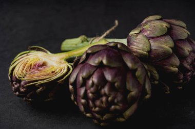 Koyu gri arka planda taze enginarlar.