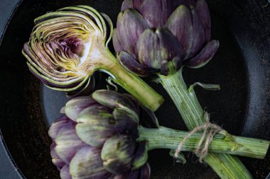 Koyu gri arka planda taze enginarlar.