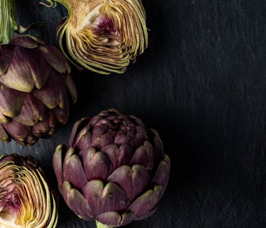 Koyu gri arka planda taze enginarlar.