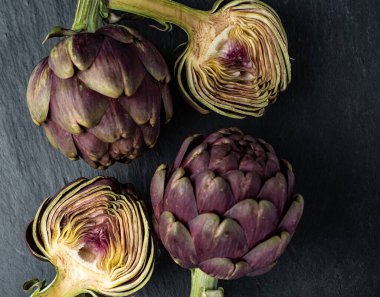 Koyu gri arka planda taze enginarlar.