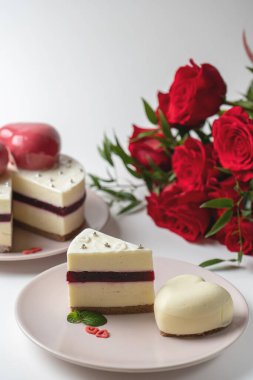 Kremalı pasta ve bir buket kırmızı gül.
