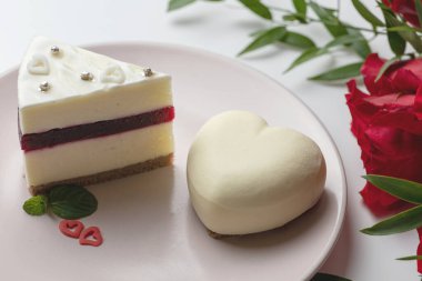 Kremalı pasta ve bir buket kırmızı gül.