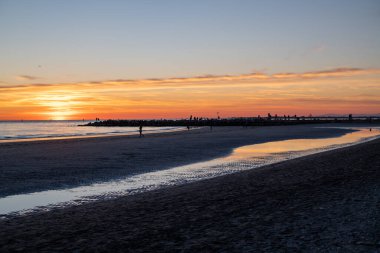Denizde gün batımı, deniz ve yoldan geçenlerle aynı seviyede güneş.