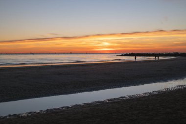 Denizde gün batımı, deniz ve yoldan geçenlerle aynı seviyede güneş.