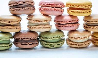 Beyaz arkaplanda çok renkli badem kurabiyeleri var.