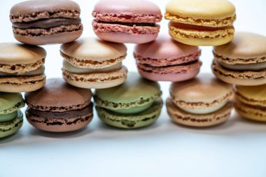 Beyaz arkaplanda çok renkli badem kurabiyeleri var.