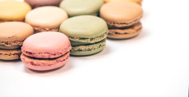 Beyaz arkaplanda çok renkli badem kurabiyeleri var.